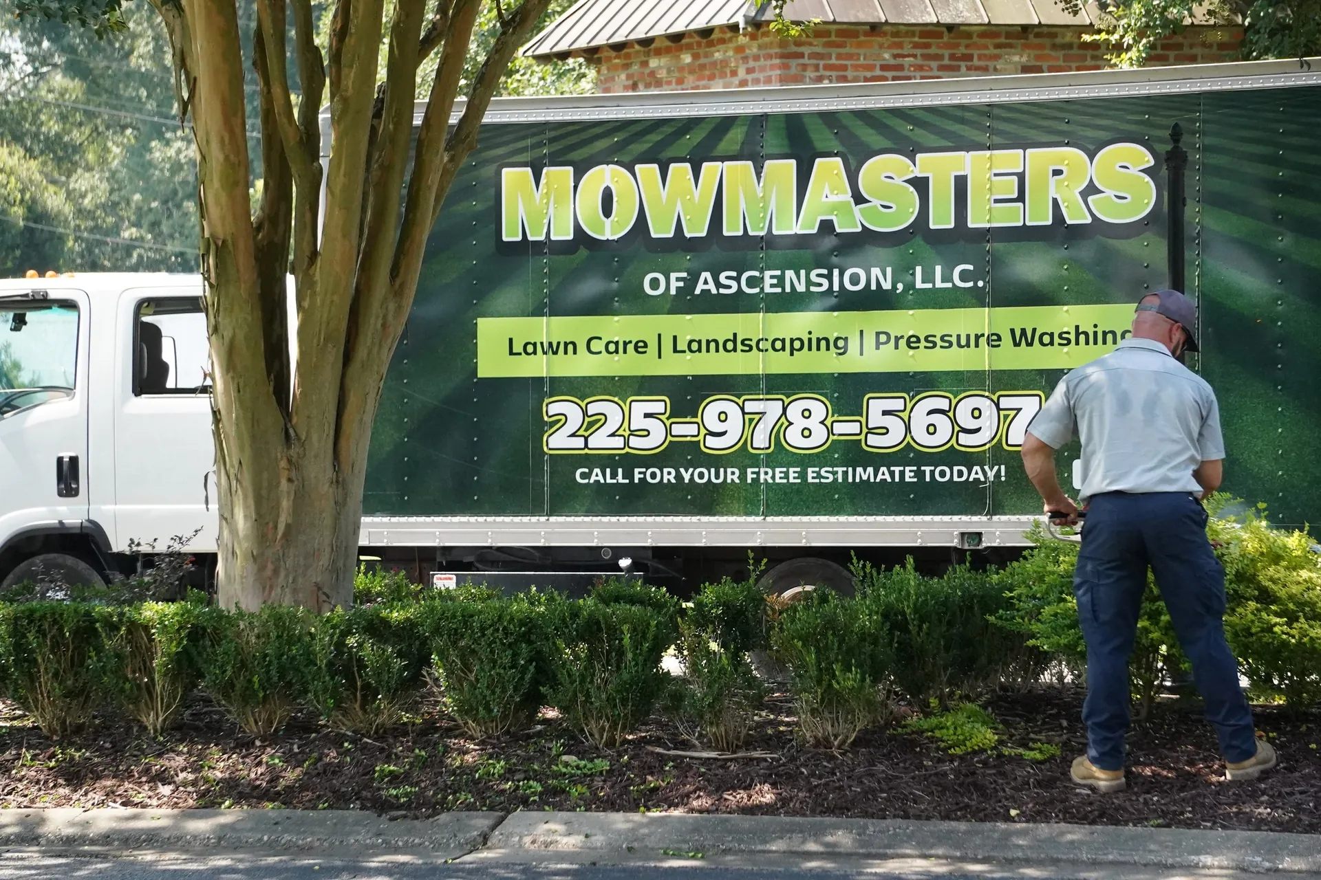 MowMasters commercial landscaping truck and trailer parked at a maintained business property in Ascension Parish, Louisiana
